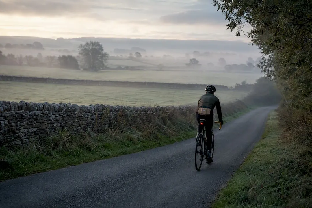 Cyclist riding through a misty valley