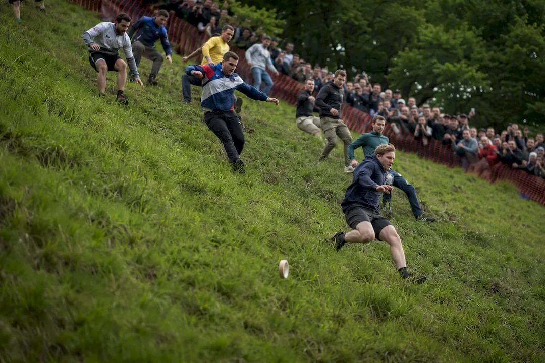 Competitors chasing cheese downhill