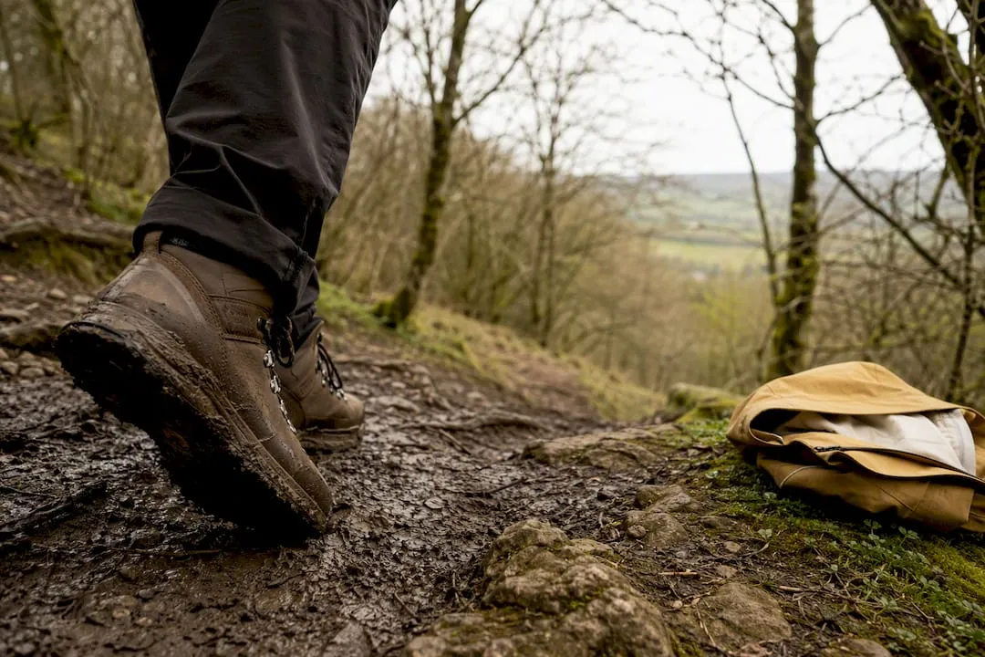 Walking boots on a muddy wooded descent