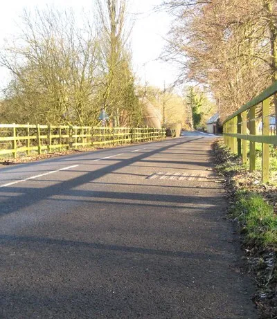 Boxford The low winter sun produces some interesting shadows of the fence on the road in this dog's eye view along the main road in Boxford leading to the river and the church.