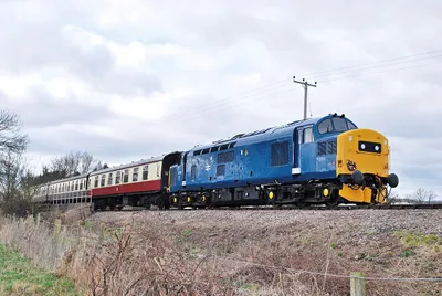 Preserved English Electric Class 37/0 1,750 hp Co-Co No.37 215 (ex-D6915) in BR blue livery, approaching Toddington with a service from Winchcome, G-WR, 3/10.