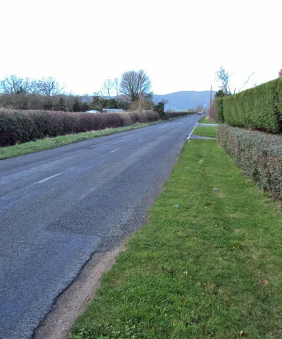 A4104 at Lower Hook Looking north-west along the straight main road heading for Welland. Pinnacle Hill in the distance.