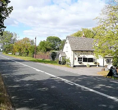 B4077 at the Hobnails Inn Looking west towards Tewkesbury.
The porch at the end of the building sags!