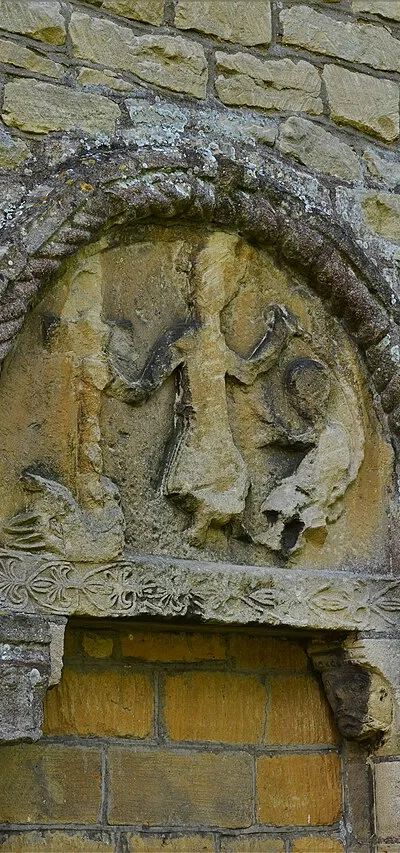 Beckford, St. John the Baptist Church: Badly worn tympanum above the blocked north doorway