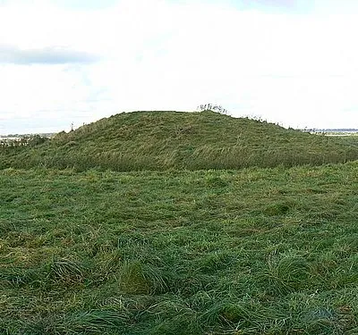 Barrow, Windmill Hill, near Winterbourne Monkton Windmill Hill was occupied about 5,500 years ago in the Neolithic period. There are signs of earthworks such as banks and ditches to be found although nowhere near as well-defined as other settlements such as Liddington and Barbury north of here in Swindon. This is a bell barrow according to the National Trust signs at the entrances to the hill. The other barrows are bowl barrows and saucer barrows. This one has a ditch around it. Beyond in the far distance can be seen the arable areas west of the Winterbournes.