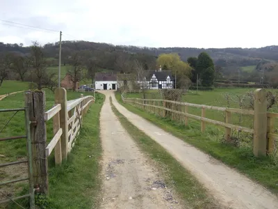 Black and white house at Great Witcombe In a fine position backed by the Cotswold escarpment.