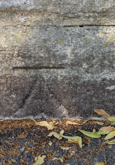 Benchmark on corner wall pier of cemetery on north side of road