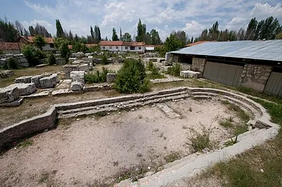 Probably in the second half of the third century AD, a second bath was built into a sturdy edifice of large limestone blocks that was already standing in the northeastern part of the city. One of the halls of this bath contains a well-preserved mosaic floor displaying a satyr and a maenad in the centre. Some time after the fourth or fifth century AD, the main hall of the bath complex was once more rebuilt in order to serve as the seat for the newly appointed bishop and head of the early Christian municipality of Aizanoi (text at site).
On the foreground: the frigidarium, with its cold plunge-bath. Large ones were also swimming pools. Usually situated on the north side of the baths complex; sometimes the water was kept cold by using snow or ice, brought in from nearby mountains.