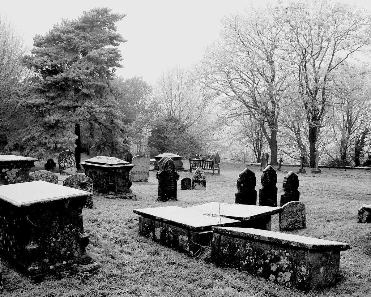 A monochrome view of the churchyard of the Parish Church of St John and St Helen, Church Hill, Wroughton, Swindon