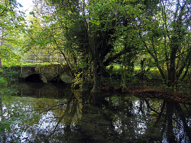 Bridge over the Lambourn. The bridge reflected in the Lambourn River in the autumn. The bridge is in the north eastern section of the square. This view looks more or less west, towards the eastern side of the bridge
