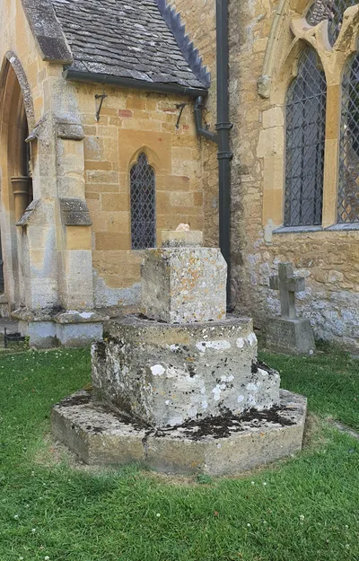 Broken war memorial in the grounds of St Nicholas church, Saintbury