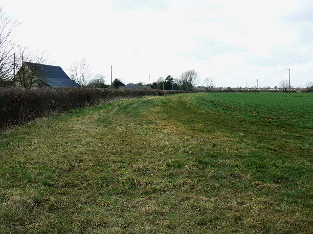 A field in Preston The cottage at the left is one of only a handful that comprise the hamlet of Preston. The eastern outskirts of Lyneham are just about discernible in the distance.
