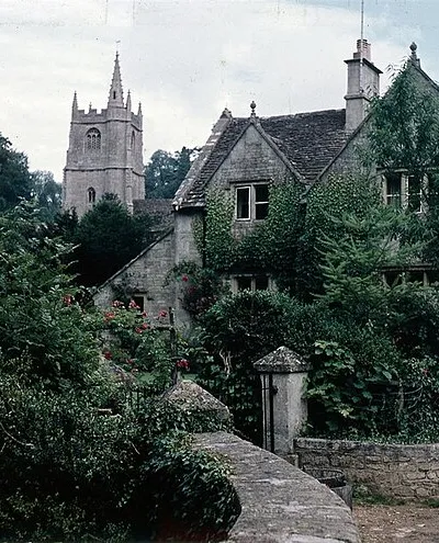 Castle Combe, 1962 House, disappearing in its own shrubbery, and the church. Taken in late spring/ early summer.
