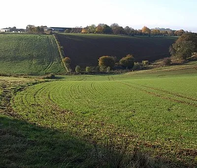 Combe, Sugarswell The valley of one of the headwaters of the Sor Brook, a tributary of the Cherwell, seen from the Macmillan Way. Beyond is Sugarswell Business Park, in SP3543, formerly a farm.