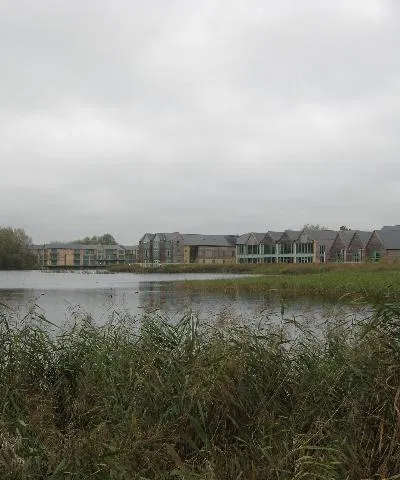 Cotswold Water Park Looking across the flooded former gravel pits towards some of the buildings erected as part of the water park development.