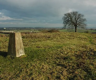 On top of Whittington Tump or Crookbarrow Hill View to the north-east from the trig point on top of Whittington Tump or Crookbarrow Hill. A bridge over the M5 motorway can be seen above the trig point, with the sun lighting Spetchley Hall in the distance. With its tree on the summit this 86m high hill is a prominent feature for travellers passing junction 7 on the M5 motorway. There is still debate as to whether this is a natural or man-made hill. There is a myth that it is a burial site from the Battle of Worcester (1651), however, some archaeologists believe it may be a very large ancient burial barrow. No archaeology dig has ever taken place on the site.