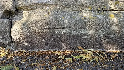 Benchmark on corner wall pier of cemetery on north side of road