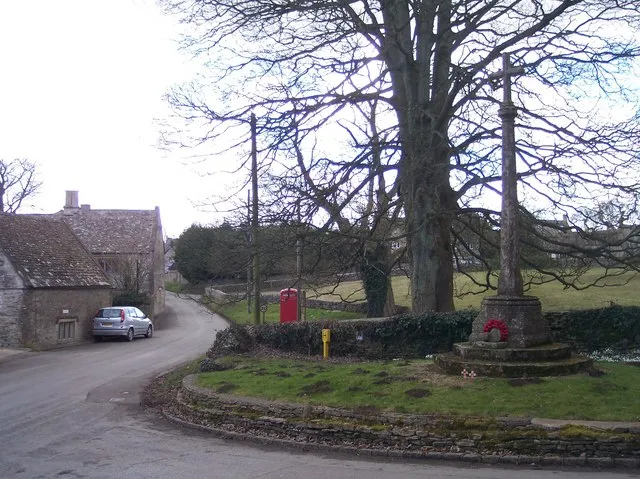 Brimpsfield Village Street and War Memorial. Looking south along the village street of Cotswold stone houses.