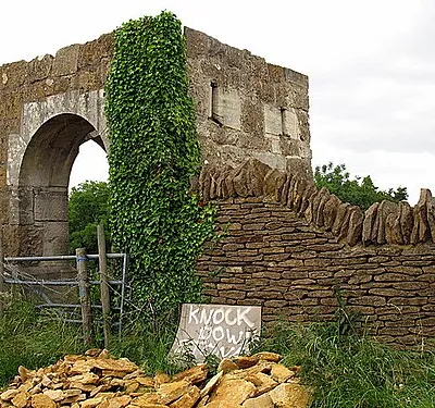 An unusual structure This arched entrance way leads to a field and nothing more.  I am intrigued as to its purpose.  It looks like it should herald the entrance to an estate, but it doesn't.  Below the wall adjacent to the road was a pile of Cotswold Stone (an oolitic limestone) and a sign saying 'knock down stones'.  No idea what that was for either - a mystery!