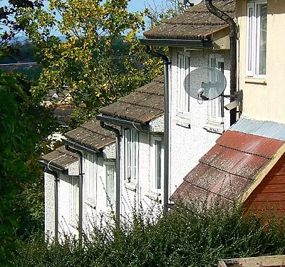 A closer look at houses in Ramsbury Avenue, Penhill, Swindon Using the zoom feature of my camera reveals little signs of these modern times. Satellite TV dishes are everywhere now beaming the dirty digger's output into homes the world over. The deployment of a CCTV camera on a modest terraced house tells us much about the fear of crime nowadays. Neither feature was in anyone's mind when the estate was developed over 50 years ago.