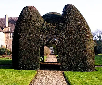Great Chalfield Manor is a National Trust property in Wiltshire.  The garden, in arts and craft style, was designed by Alfred Parsons: it contains this unusual yew topiary in the form of a house.