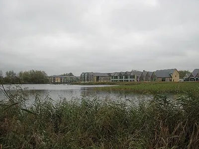 Cotswold Water Park Looking across the flooded former gravel pits towards some of the buildings erected as part of the water park development.