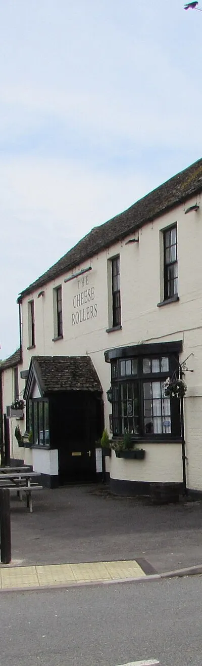 The Cheese Rollers, Shurdington. The pub on the corner of Shurdington Road and Farm Lane is named for The Cooper's Hill Cheese Rolling and Wake, an annual event held on the Spring Bank Holiday at Cooper's Hill near Gloucester.