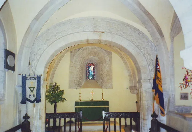 Church of England parish church of St John the Evangelist, Elkstone, Gloucestershire: chancel arch and chancel. The yellow colour in the chancel is natural rather than artificial light as it might at first seem.