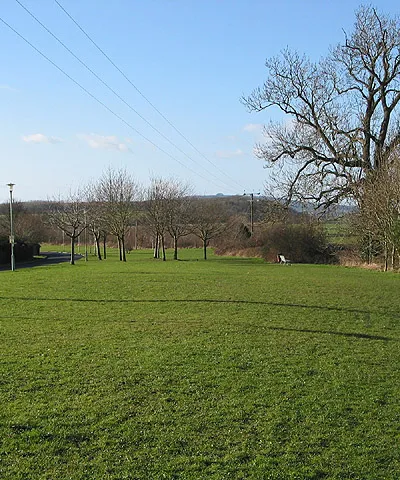 Edge of a housing estate The periphery of this estate has a wide grass verge which obviously gets a lot of use at the weekends judging by the prints of many football boots. Looking almost due west in this shot towards May Hill on the horizon.
