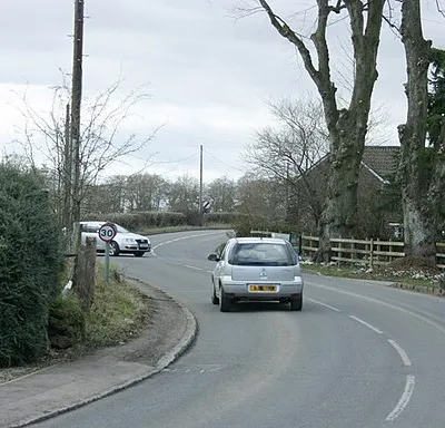 A342 heads north at Sandy Lane Illustrating the need to drive at reasonable speed through these bends. Less dangerous than it looks due to foreshortening.