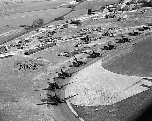 Douglas Dakotas of No. 233 Squadron RAF lined up on the perimeter track at Blakehill Farm, Wiltshire, for an exercise with the 6th Airborne Division, 20 April 1944.
Oblique aerial photograph showing Royal Air Force (RAF) Douglas Dakotas of No. 233 Squadron RAF, lined up on the perimeter track at RAF Blakehill Farm in Wiltshire, for an exercise with the 6th Airborne Division.