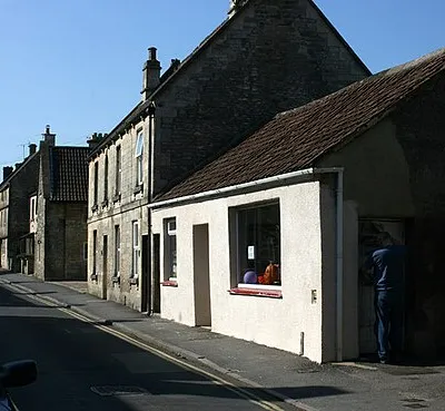 High Street, Colerne To its villagers Colerne is known as the village on the hill and this sums up both its position and much of its history. The parish lies on an upland spur of land with the valley of the By Brook to the south and east and a scarp slope to the north where the land drops steeply to North Wraxall. Much of the parish lies on limestone with Great Oolitic limestone in the north, which has been used for much of the local building. In the south, where the land falls away below the village, is an area of sands, rubbly limestone and some clay. Traditionally the higher land was used for sheep-rearing with corn and root crops grown on the lower.
The above was copied from: http://www.wiltshire.gov.uk/community/getcom.php?id=65  where you will find much more.