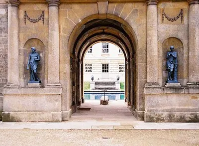 Arch and two statues at Buscot House. Through this archway can be glimpsed the swimming pool and the east end of the main house. The arch itself is also interesting for the mural painted on part of the interior wall on the lefthand side. 1223028