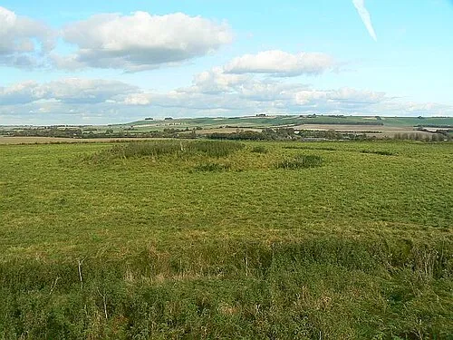 A view north-east from Windmill Hill, near Winterbourne Monkton. The viewpoint is the top of this barrow 1010949 In the foreground is another barrow, this time a bowl barrow. Hackpen Hill is in the far distance.