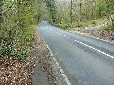 B4014 to Avening The road connects the towns of Nailsworth, behind the viewpoint, and Avening. It just clips the south-western corner of the square. Gatcombe Wood is to the left of the road.