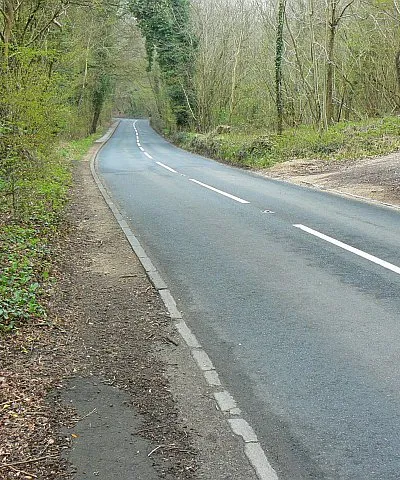 B4014 to Avening The road connects the towns of Nailsworth, behind the viewpoint, and Avening. It just clips the south-western corner of the square. Gatcombe Wood is to the left of the road.