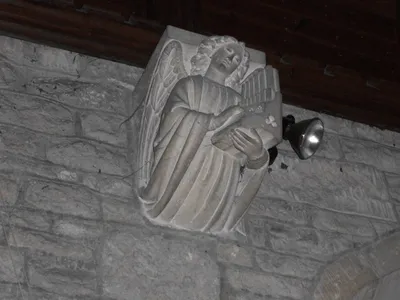 Corbel in the chancel of St Martin's parish church, Woolstone, Gloucestershire, representing an angel playing an organ
