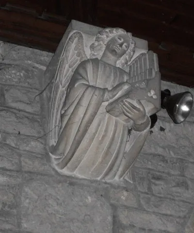 Corbel in the chancel of St Martin's parish church, Woolstone, Gloucestershire, representing an angel playing an organ
