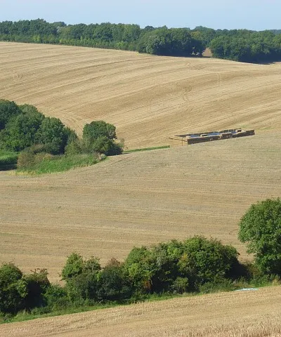 Farmland, Witcha Looking across stubble fields that span the dry valleys above Witcha. Slightly left of centre is a grass hummock which is the tumulus marked on the map. To the right of that is large stack of straw bales. These are just east of Witcha Copse (i.e. just outside of this grid-square).