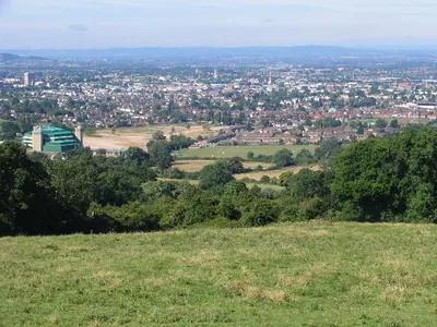 Above Noverton. This square is filled by the steep south western slopes of the southern end of the Cleeve Hill/Common area. This view looks south west down the slopes across Cheltenham and into the Severn Vale. The green building in the left foreground is part of the old GCHQ complex.