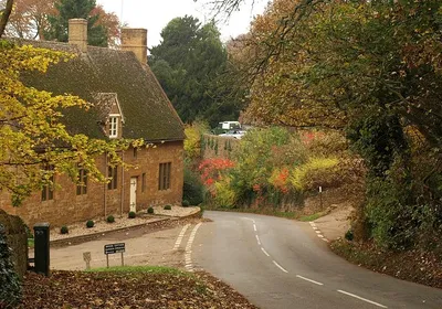 Alkerton, Oxfordshire: road from Alkerton Barn into the village past Well Lane (left) and an ironstone house