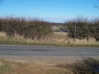 Crossing of a bridleway and a minor road near Lidstone, Oxfordshire. The roof visible through the gap in the hedge is that of Lidstone Court.