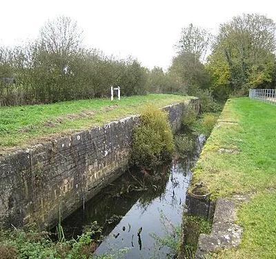 Boxwell Springs Lock. This lock was added to the canal some 3 years after the canal first opened in the 1780s, and the pound from here to 1049511 was lowered by 3ft 6ins order to improve the water supply available from the nearby Boxwell Springs.  This is why this lock has a relatively small fall when compared with others on the Thames and Severn Canal.  The chamber was restored between 1993 and 1995.