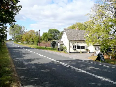 B4077 at the Hobnails Inn Looking west towards Tewkesbury.
The porch at the end of the building sags!