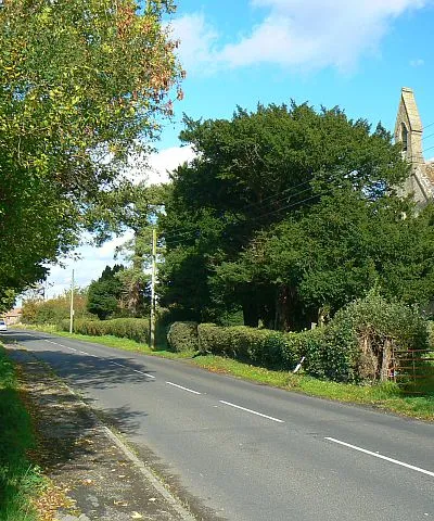 Broad Town Road, Broad Town The road is seen leading to the north towards the market town of Wootton Bassett. At the right is the bell tower of Christ Church.