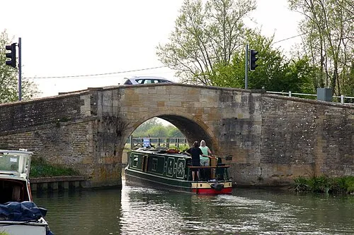 A narrowboat passes under Radcot Bridge