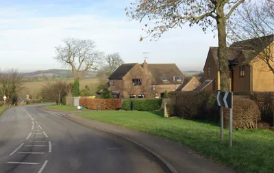 B4035 west of Tadmarton The B4035 approaches Tadmarton from the west via a double bend past a small development of modern houses.