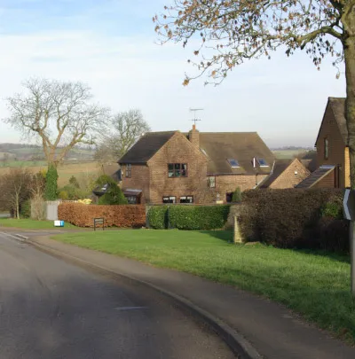 B4035 west of Tadmarton The B4035 approaches Tadmarton from the west via a double bend past a small development of modern houses.