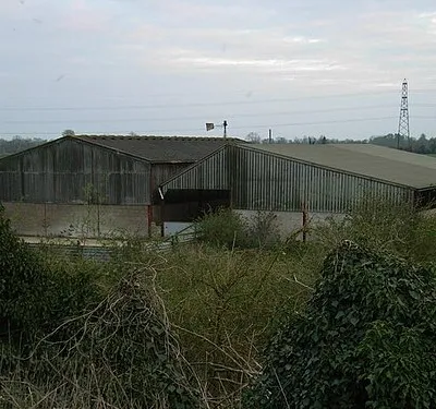 Barn With derelict windpump 405415 and power lines behind.