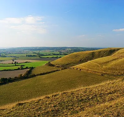 A view from Oliver's Castle, near Heddington The viewpoint is the western edge of the early Iron Age univallate hillfort. At the right is the edge of the Beacon Hill escarpment, which is access land. Although the land at the foot of the hill is farmland it is possible to cross it via a footpath. The line of sight is across the two degrees west meridian which, uniquely in the UK, coincides with an OSGB1936 south-north gridline.